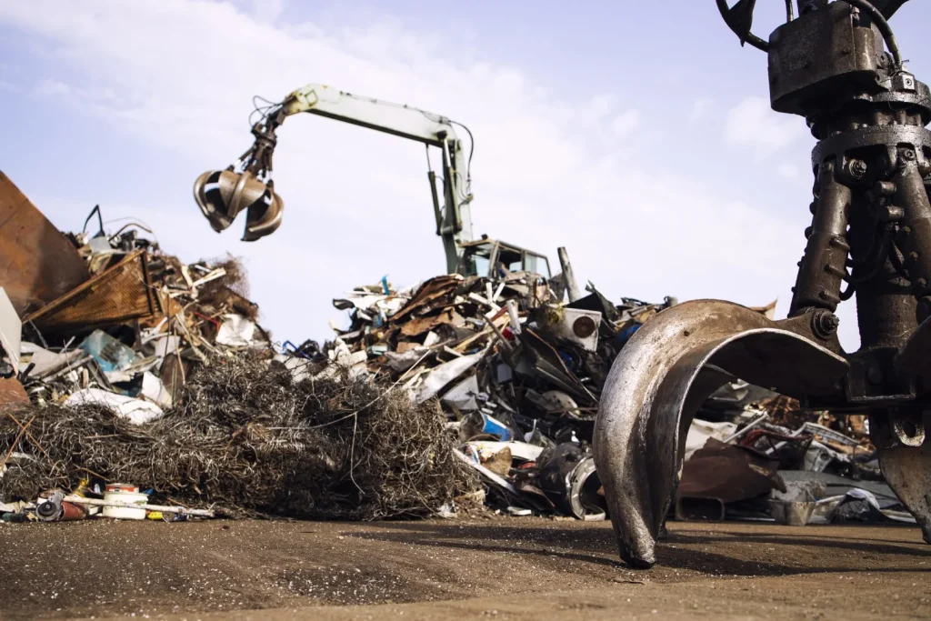 metal-junk-yard-with-hydraulic-lifting-machine-with-claw-attachment-scrap-metal-recycling 